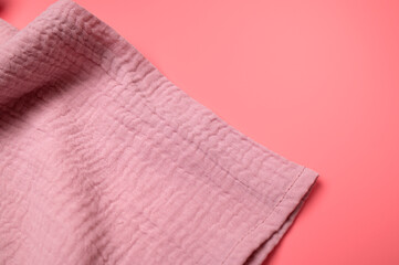 Texture of pink muslin fabric on pink background. Cotton textile and clothing. Soft delicate natural organic cotton fabric for sewing, needlework, baby towel, diaper, dress. Fabric background - obrazy, fototapety, plakaty