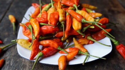 Close up ripe cayenne pepper (cabe rawit) on white plate. Vegetable background.