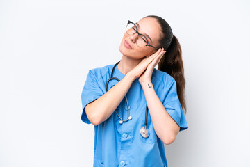 Young caucasian surgeon doctor woman isolated on white background making sleep gesture in dorable expression