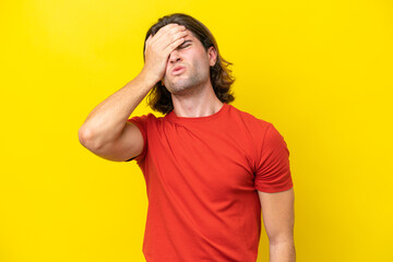 Caucasian handsome man isolated on yellow background with headache