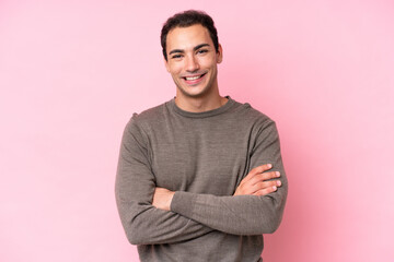 Young caucasian man isolated on pink background keeping the arms crossed in frontal position