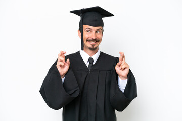 Young university graduate man isolated on white background with fingers crossing