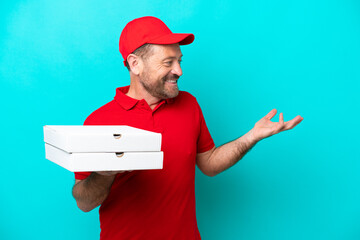 Pizza delivery man with work uniform picking up pizza boxes isolated on blue background with...
