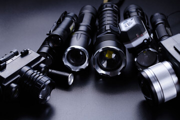 Set of black pocket tactical flashlights isolated on black background