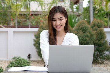 Cheerful smiling mid aged woman using laptop for work