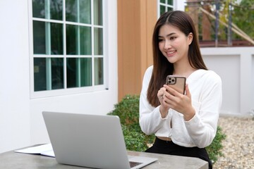 Woman on the phone working on balcony at home