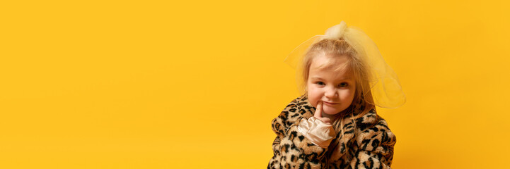 Banner of little funny girl with finger near mouth over yellow background. Concept of human emotions, fashion, ad, child model
