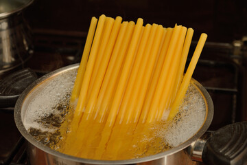 Thick pasta in a pot of boiling water, close-up.