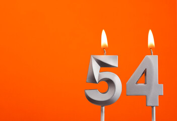 Number 54 - Silver Anniversary candle on orange background