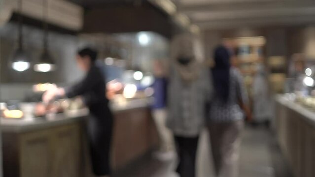 Blurred interior of a big beautiful restaurant and diners come to pick and pick food.