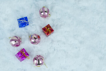 Glittered Christmas baubles with colorful presents with metallic strings