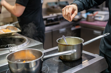 Obraz na płótnie Canvas Chef hands cooking sauce in the restaurant kitchen