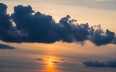Obraz premium Big dark cloud over setting sun