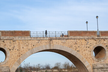 Obraz premium Personas caminando por un puente, visto desde abajo.