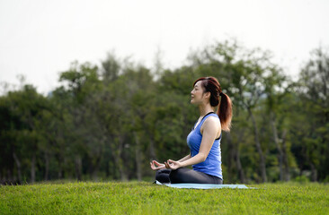 young attractive woman doing yoga,calm and happy mind in the green nature park, concept for taking care physical health,mental health and spirituality