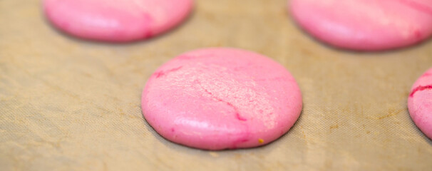 Obraz na płótnie Canvas pink halves for macaroons cookies on the table. home bakery concept.