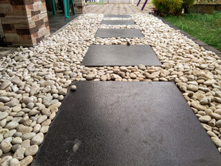low angel of a garden with white decorative stones and black marble