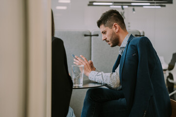 Tired businessman checking his phone at work