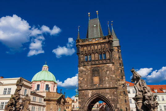 Prague old historical center beautiful architectures with Charles Bridge baroque statues, medieval Old Town Bridge Tower and St. Francis Of Assisi Church beautiful dome