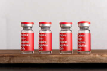 Closeup of coronavirus vaccine vials on the wooden table.