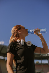 Fototapeta na wymiar Beautiful female jogger drinking water