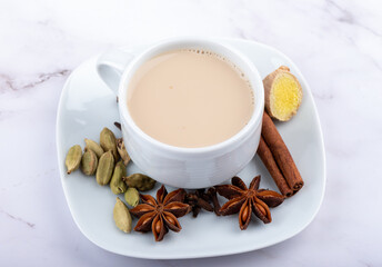 Obraz na płótnie Canvas A cup of masala tea on a saucer with spices.
