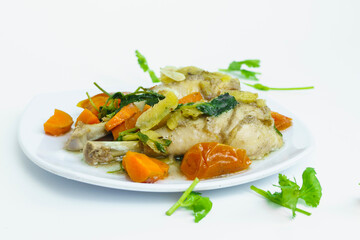 Steamed chicken with herbs and vegetables on white plate