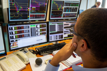Salle des marchés. Négociation sur les marchés à terme. Trader consultant les variations des...