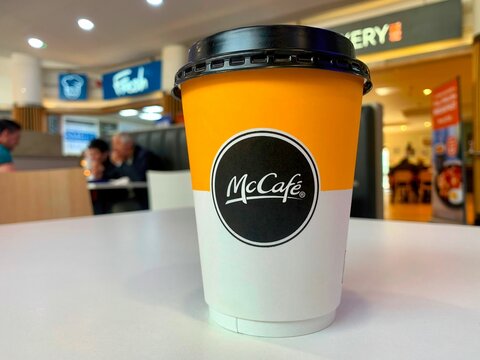 Selective focus shot of a McCafe hot drink takeaway cup on a white table