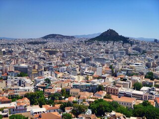 Aerial shot of the cityscape of Athens with hundreds of buildings under the blue sky