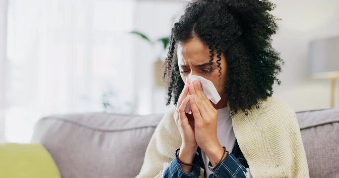 Sick woman, tissue and blowing nose in home of allergies, cold virus or hayfever on sofa lounge. Female, sneeze and influenza allergy of winter health problem, covid medical risk or sinusitis disease