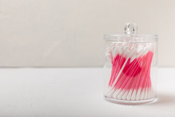 Cotton buds on a light concrete background. Hygienic cotton sticks with cotton flowers on a textural background.ear sticks. Place for text. Place to copy.Closeup.