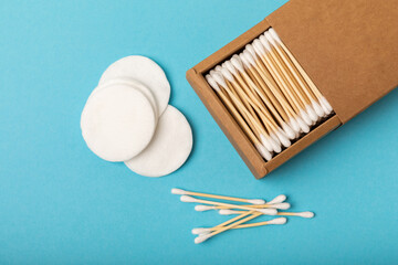 Cotton buds and cotton pads on a blue background.Eco-friendly materials. Wooden, cotton swabs on a white background.Bamboo swabs and cotton flowers.Zero waste, plastic free lifestyle concept.Place for