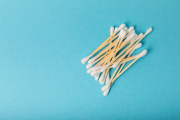 Cotton buds on a blue background.Eco-friendly materials. Wooden, cotton swabs on a white background.Bamboo swabs and cotton flowers.Zero waste, plastic free lifestyle concept.Place for text.