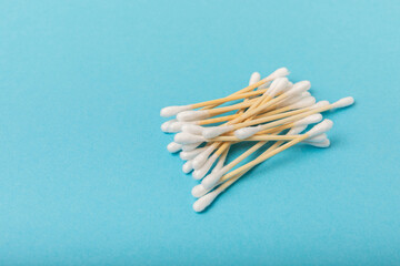 Cotton buds on a blue background.Eco-friendly materials. Wooden, cotton swabs on a white background.Bamboo swabs and cotton flowers.Zero waste, plastic free lifestyle concept.Place for text.