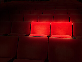 Obraz premium 映画館のスポットライトで浮かぶ赤の2座席
