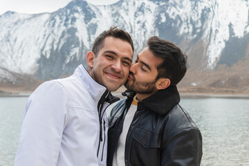 Loving young homosexual couple near lake