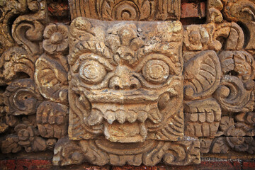 Bali sculpture in stone wall.