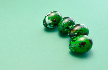Blue green Easter quail eggs on blue background. Minimalism. Pascha or Resurrection Sunday, Christian festival and cultural holiday concept. Copy space for text on right side. Horizontal plane.