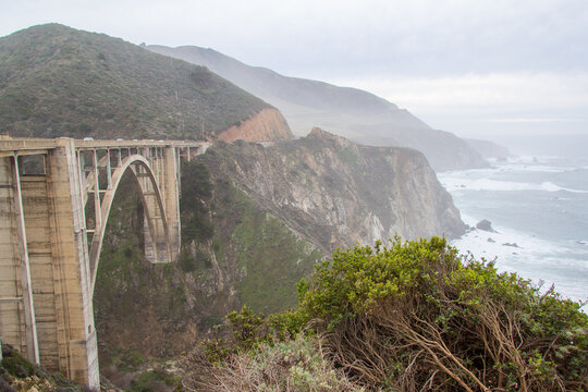 Bixby Bridge with the rocky Big Sur coastline behind in it off the Pacific Coast Highway in California.