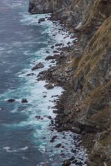 Obraz premium The rocky California coastline as off the Pacific Coast Highway near the Big Sur area. Classic foggy conditions and rough waters.