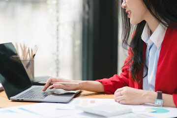 Crooped shot of a beautiful Asian businesswoman is using a digital laptop at her desk in a modern...