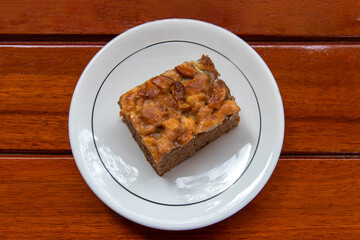 Chocolate cake on a white plate look appetizing placed on a wooden table