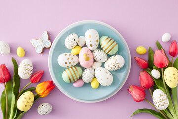 Easter concept. Flat lay photo of blue empty plate with white yellow easter eggs butterfly cookies and red tulips flowers on isolated violet background
