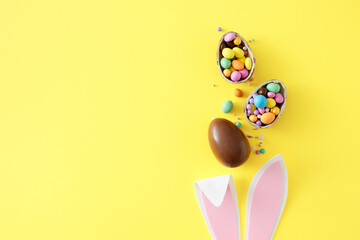 Easter sweets concept. Top view photo of rabbit bunny ears chocolate eggs with сolorful candies on...