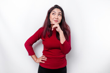 A thoughtful young woman dressed in red while looking aside, isolated by white background