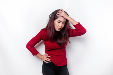 A portrait of an Asian woman wearing a red top isolated by white background looks depressed