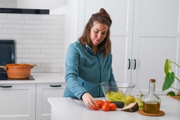 young girl preparing a salad in the kitchen