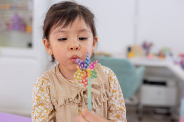Girl blowing into a pinwheel in a doctor's office