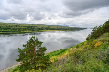 View of the Tom River in the Siberian taiga under a stormy sky in summer